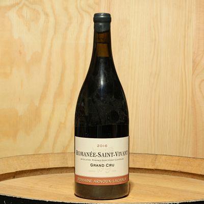 a bottle of wine sitting on top of a wooden barrel