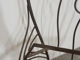 a wrought iron bench with a bird design on it