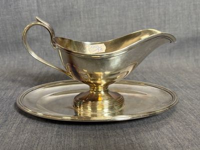 un service en argent ancien composé d'une assiette et d'une soucoupe posée dessus