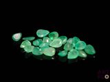 a close up of a bunch of green gems on a black surface