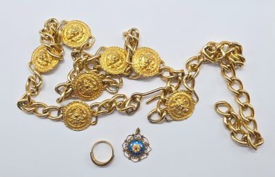 un gros plan sur une chaîne ornée de pièces d'or et d'une bague