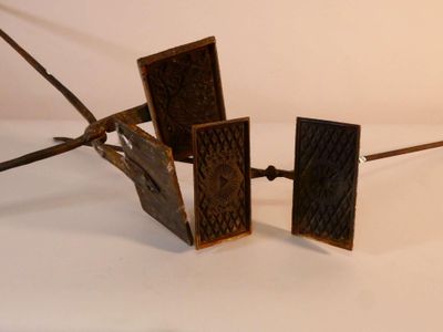 trois morceaux de métal posés sur une surface blanche