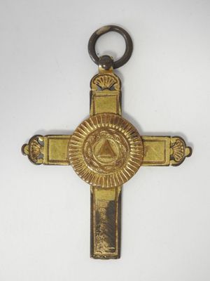 une image représentant une croix en or sur laquelle figure un œil qui voit tout