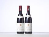 two bottles of red wine sitting on top of a table