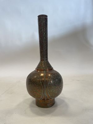an antique bronze vase on a white surface with a white background