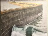une grande photo d'un homme surfant sur une vague avec sa planche de surf
