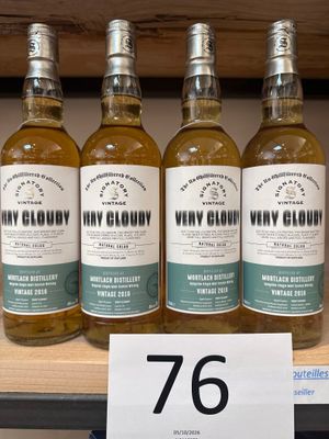 quatre bouteilles de whisky posées sur une étagère dans un magasin