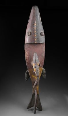 un gros plan sur une sculpture représentant un poisson, sur fond noir