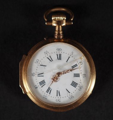 a gold pocket watch with roman numerals on the face