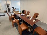 une longue table avec des chaises et une bouteille de vin posée dessus