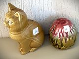 deux figurines en céramique représentant des chats assis l'un à côté de l'autre
