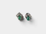 a pair of emerald and diamond earrings on a white background