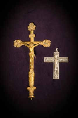 a close up of a cross and a gold cross on a purple background