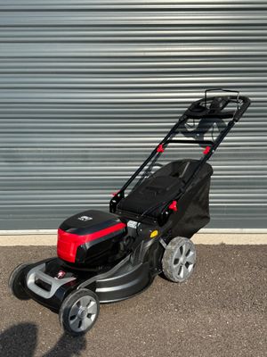 l'image d'une tondeuse à gazon garée devant une porte de garage
