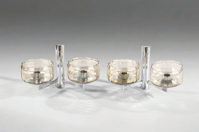 trois bougeoirs en verre transparent posés sur une surface blanche