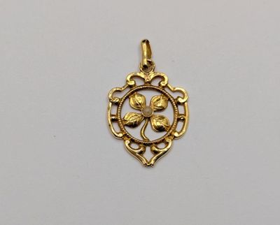 a gold plated pendant with a flower in the center