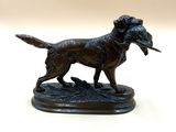bronze statue of a dog with a bird in its mouth