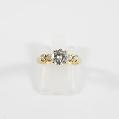 une bague en or jaune sertie d'un diamant blanc et de trois diamants