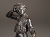 bronze statue of a man with a hat and a cane