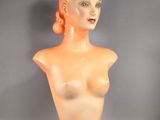le buste orange d'une femme sur fond gris