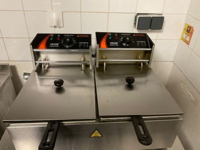 two deep fryers sitting on top of each other in a kitchen
