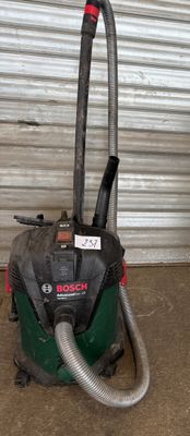un aspirateur posé par terre devant la porte d'un garage