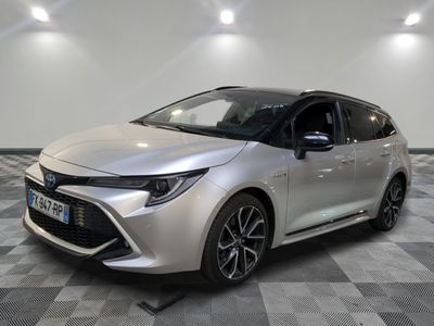 the silver toyota corolla is parked in a room with a checkered floor