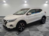 un SUV Nissan blanc garé sur un sol en carrelage à damier