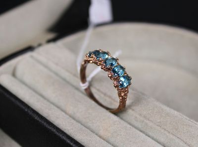 une bague posée dans une boîte ornée d'un ruban