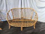 a wicker bench that is sitting in front of a curtain