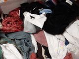 a suitcase full of clothes and clothes sitting on the floor