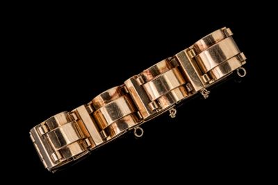 une image montrant un gros plan d'un bracelet en or sur fond noir