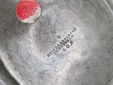 a red dot on the bottom of a silver plate