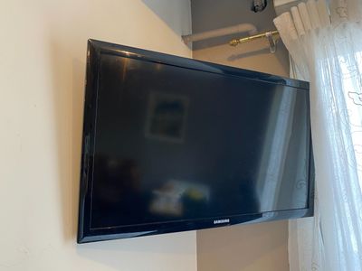 une télévision à écran plat fixée au mur au-dessus d'une fenêtre