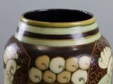 a brown vase with green and white designs on it