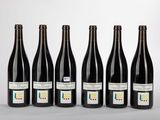 six bouteilles de vin alignées sur une table