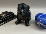 une figurine de chien assise à côté d'un livre et d'une balle bleue