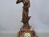 a statue of a woman holding a bird and a clock