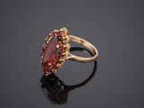 a close up of a gold ring with a red stone