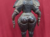 une vieille statue en bronze représentant une femme coiffée d'un chapeau