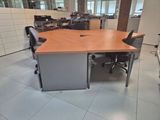 a desk with two chairs and a computer monitor in the corner
