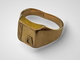 a close up of a gold ring on a white surface