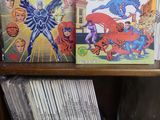 des livres posés sur une étagère d'une bibliothèque où se trouvent également des bandes dessinées