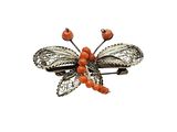 a close up of a butterfly brooch with red berries on it
