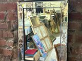 a mirror hanging on a brick wall with books on it