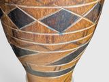 a large wooden vase with a design on it