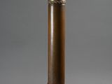 an old brass pipe with a metal cap on a gray background