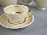 a cup and saucer sitting on a table next to a plate