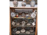 de nombreuses assiettes et vases posés sur une étagère dans une pièce