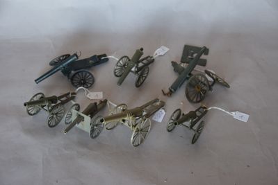 beaucoup de pistolets jouets et un canon posés sur une table